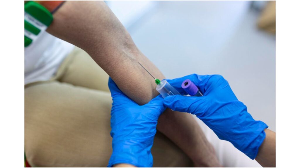 A phlebotomist is taking blood from a patient
