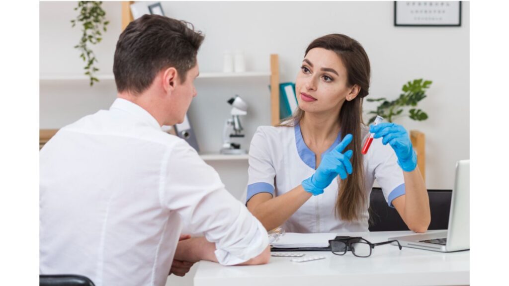 A phlebotomist showing a blood specimen to a trainee